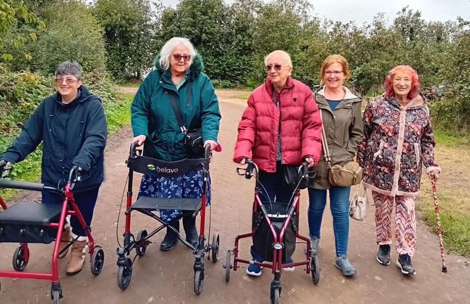 a group of adults enjoying a walk amongst autumn trees at Perry Court Farm