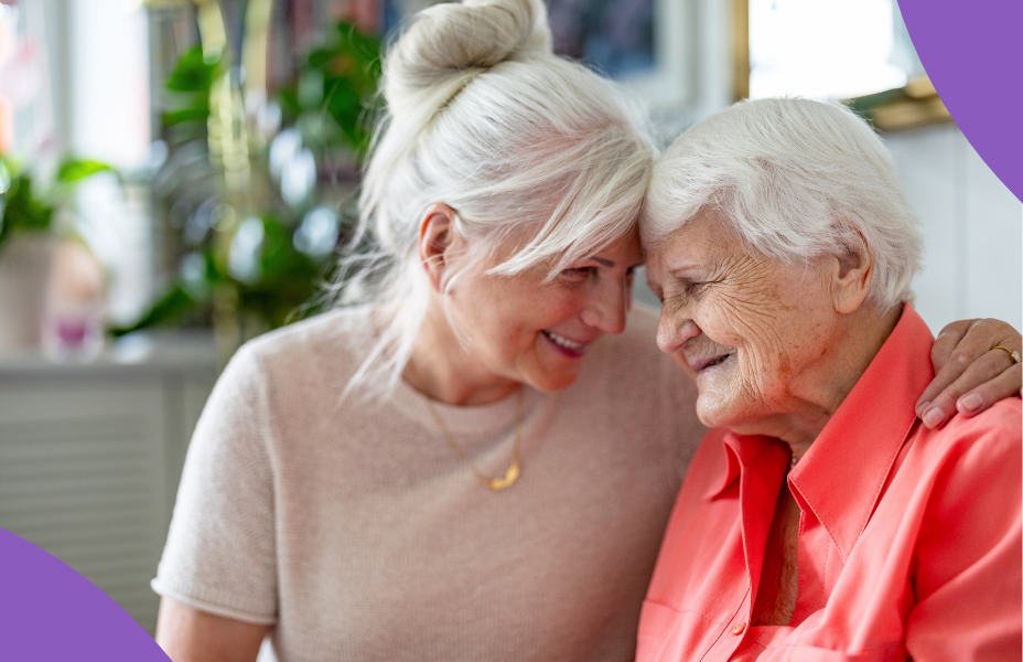 A carer embracing her older mother. Both are smiling