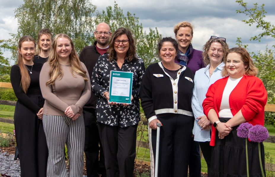Imago staff holding up the Excellence for Carers award from Carers Trust