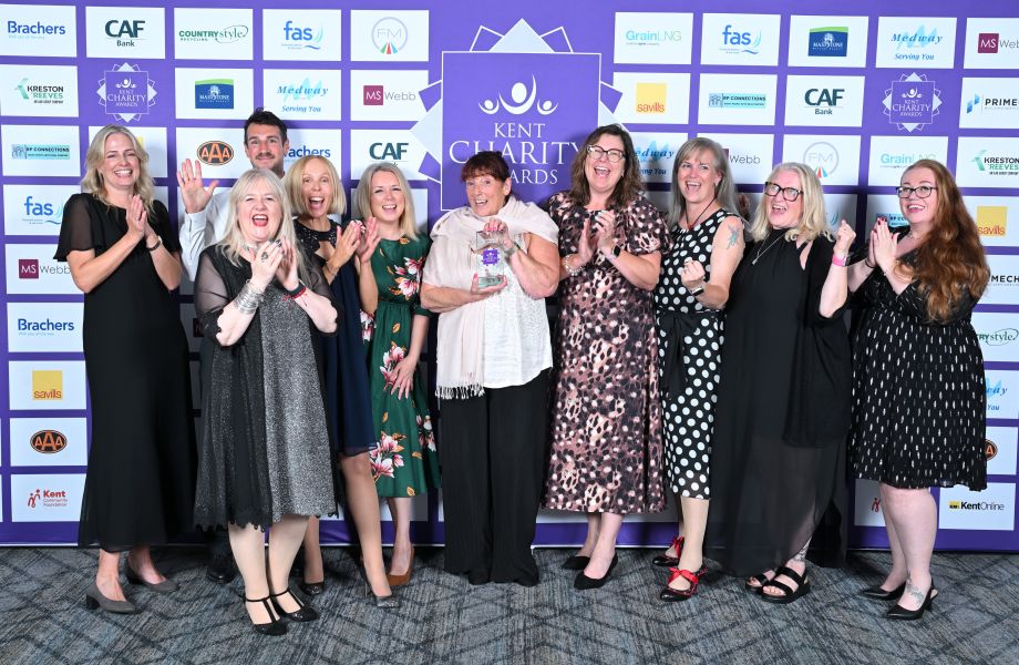 From left to right, Louise Sam, Ashley, Angela, Jo, Caroline, Liz, Jo, Maggie and Ruth standing together holding the Kent Charity Award Trophy 2026