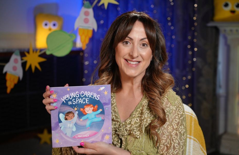 Natalie Cassidy holding up a copy of Young Carers in Space