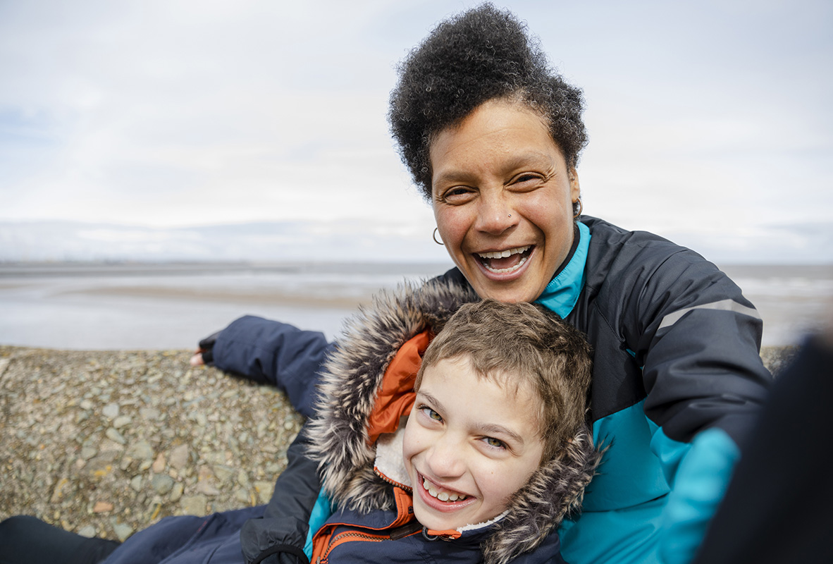Image of mother and child cuddling on the beach